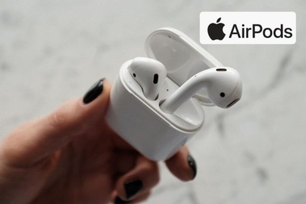 Main tenant des AirPods avec un logo Apple en arrière-plan