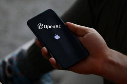 Personne tenant un iPhone avec les logos Apple et OpenAI à l'écran.