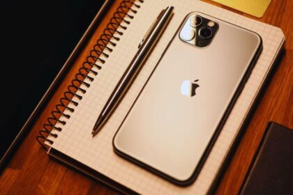 iPhone posé sur un cahier à côté d'un stylo